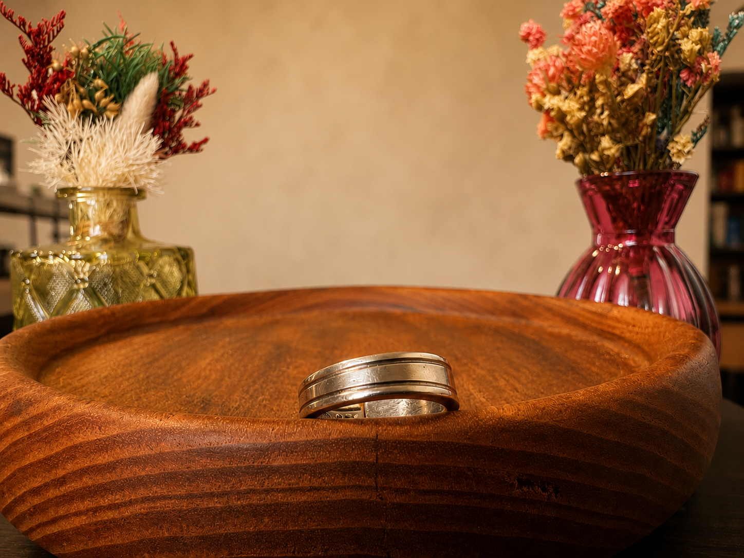 Ridged band ring on wooden bowl